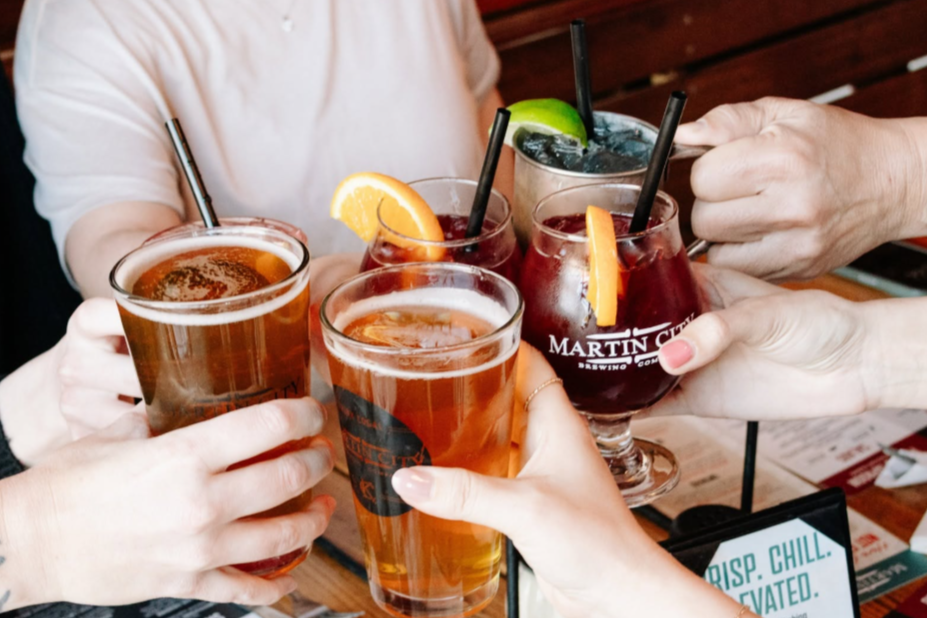 individuals gathering drinks in the middle of a table